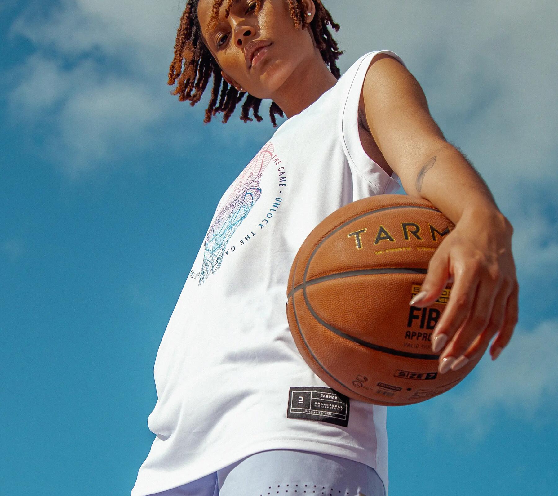 Woman holding basketball and looking at camera