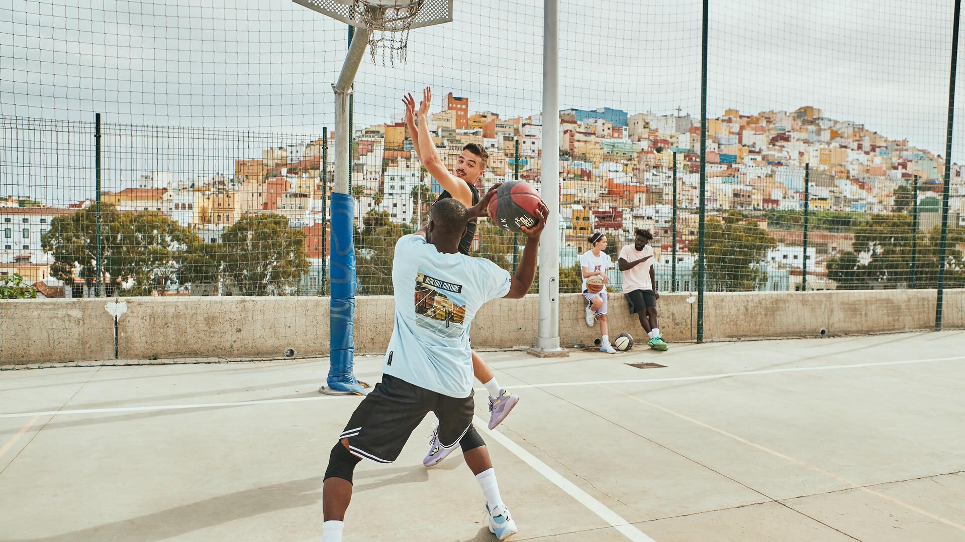 Two men playing basketball in outdoor court