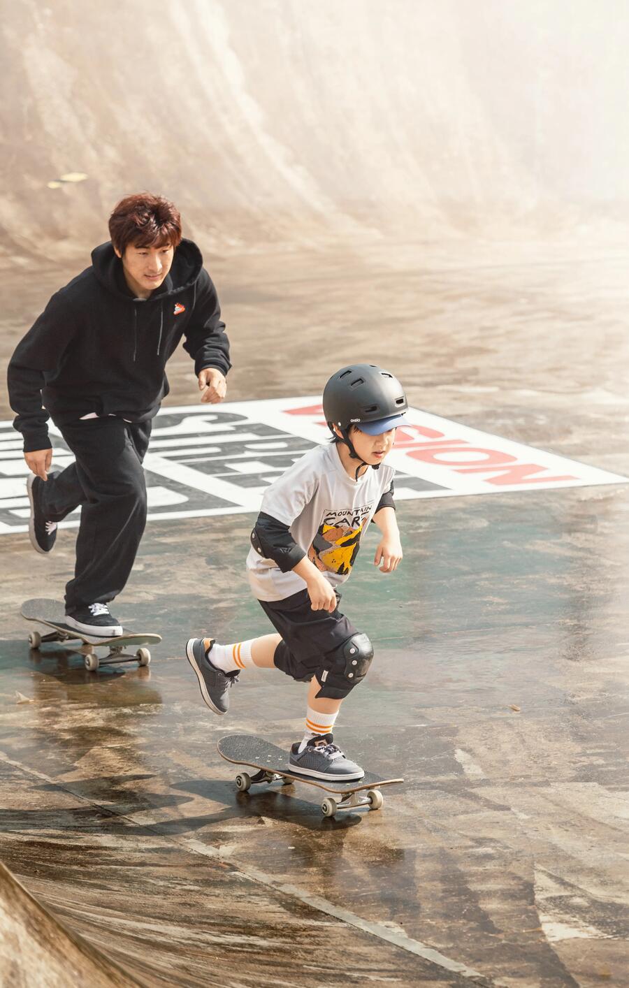 Teenager and young boy skating at a skate park