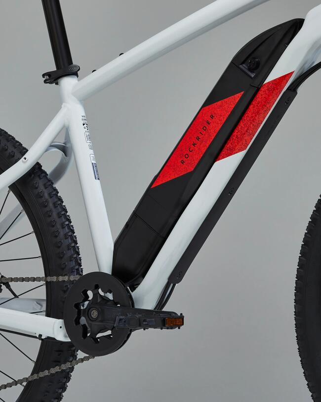 Weißes Fahrrad mit roten und schwarzen Details, robusten Reifen und markantem Rahmendesign auf grauem Hintergrund.