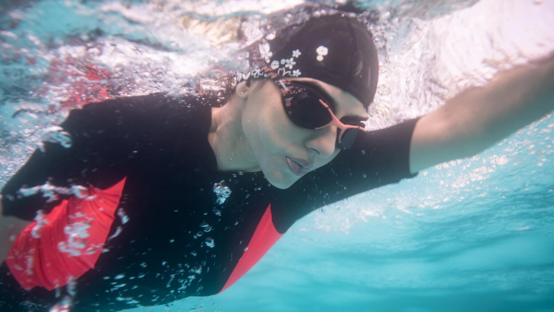 Person nutzt Schwimmbrille im Schwimmbad