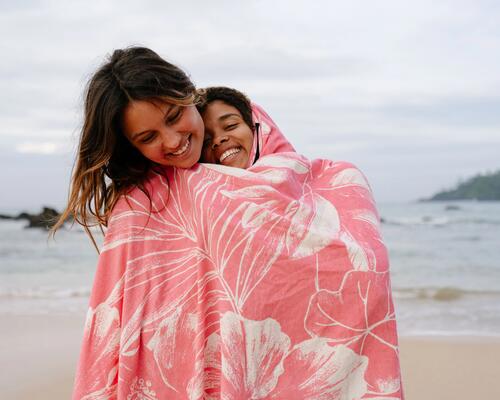 kobiety owinięte ręcznikiem typu ponczo na plaży 