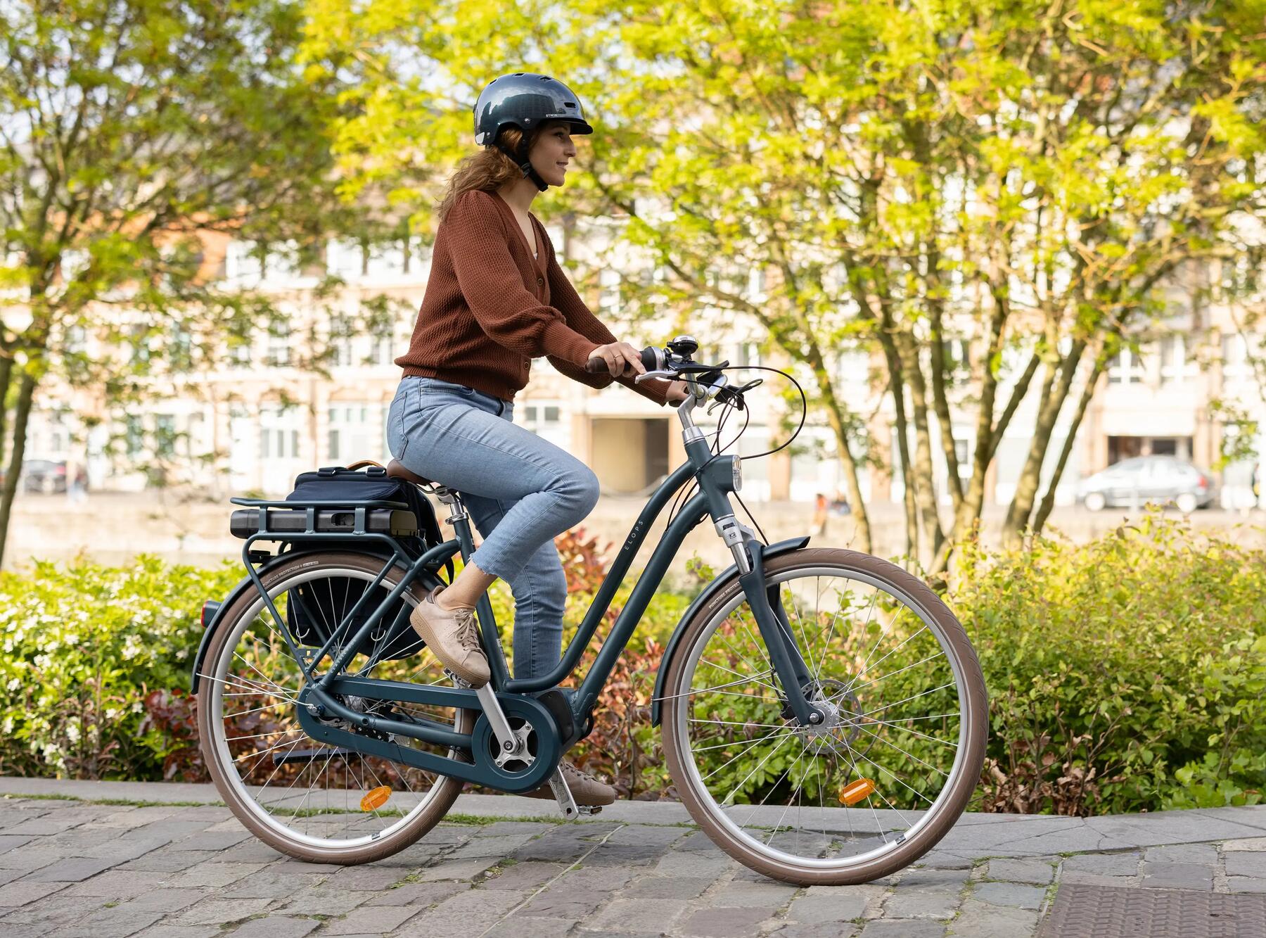 kobieta w kasku rowerowym jadąca na rowerze elektrycznym zgodnie z przepisami ruchu drogowego