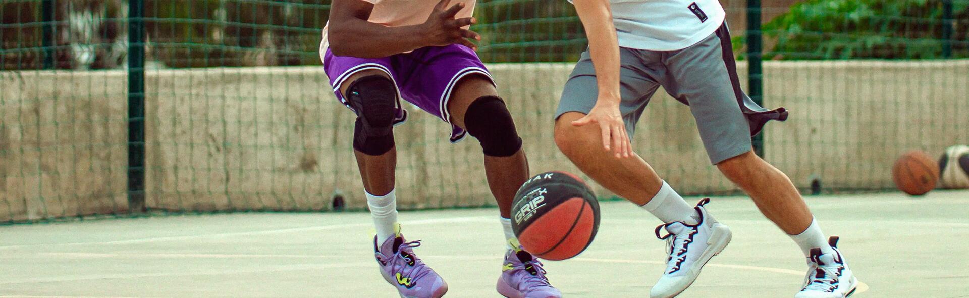 Two men playing basketball and dribbling