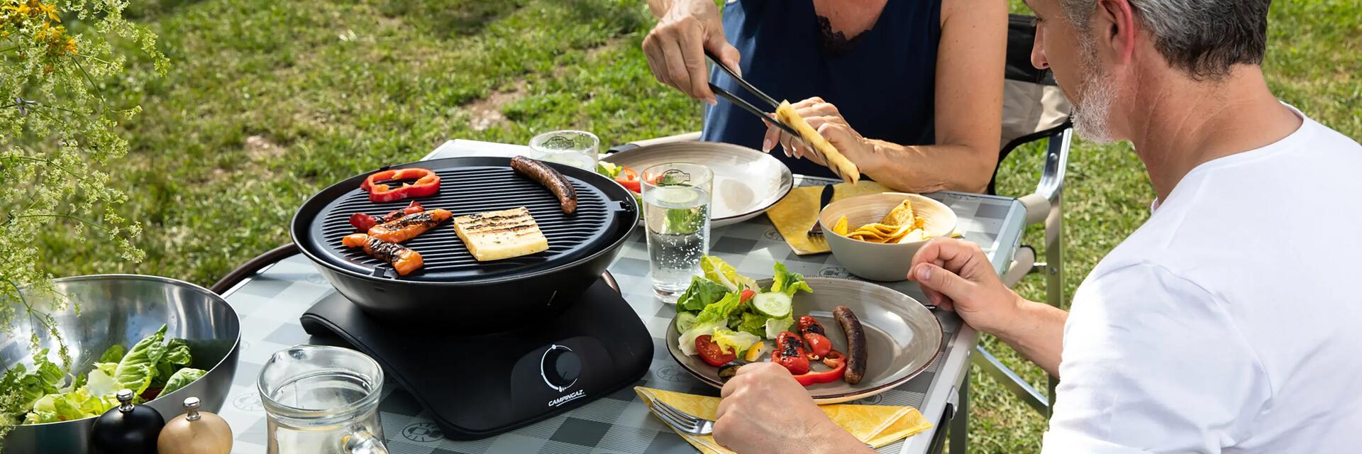 pareja cocinando en camping