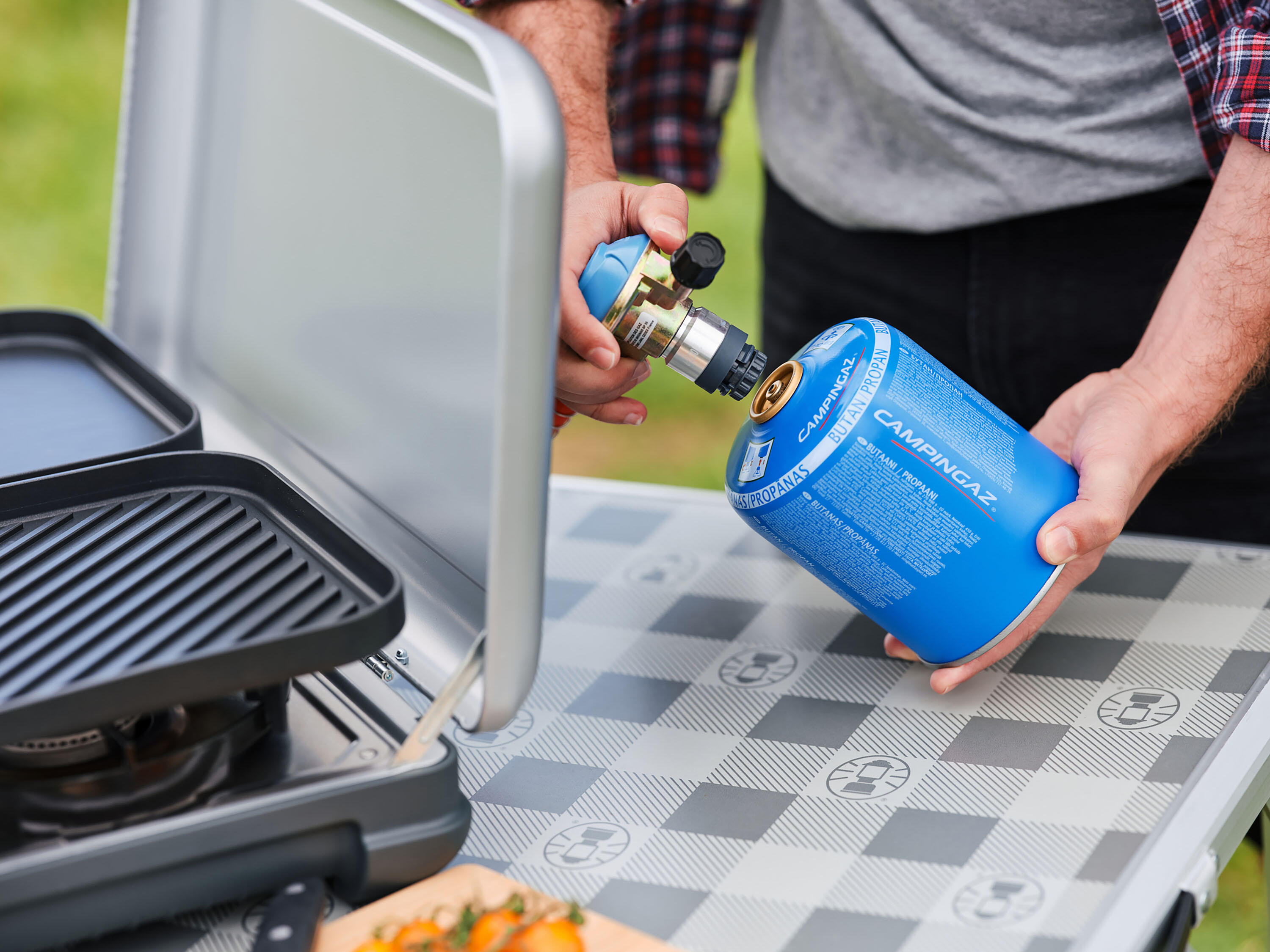 Butane gas canister connected to a portable camping stove on an outdoor table