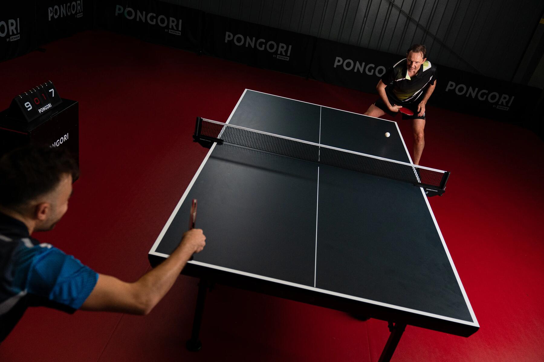Two men paying indoor table tennis ball