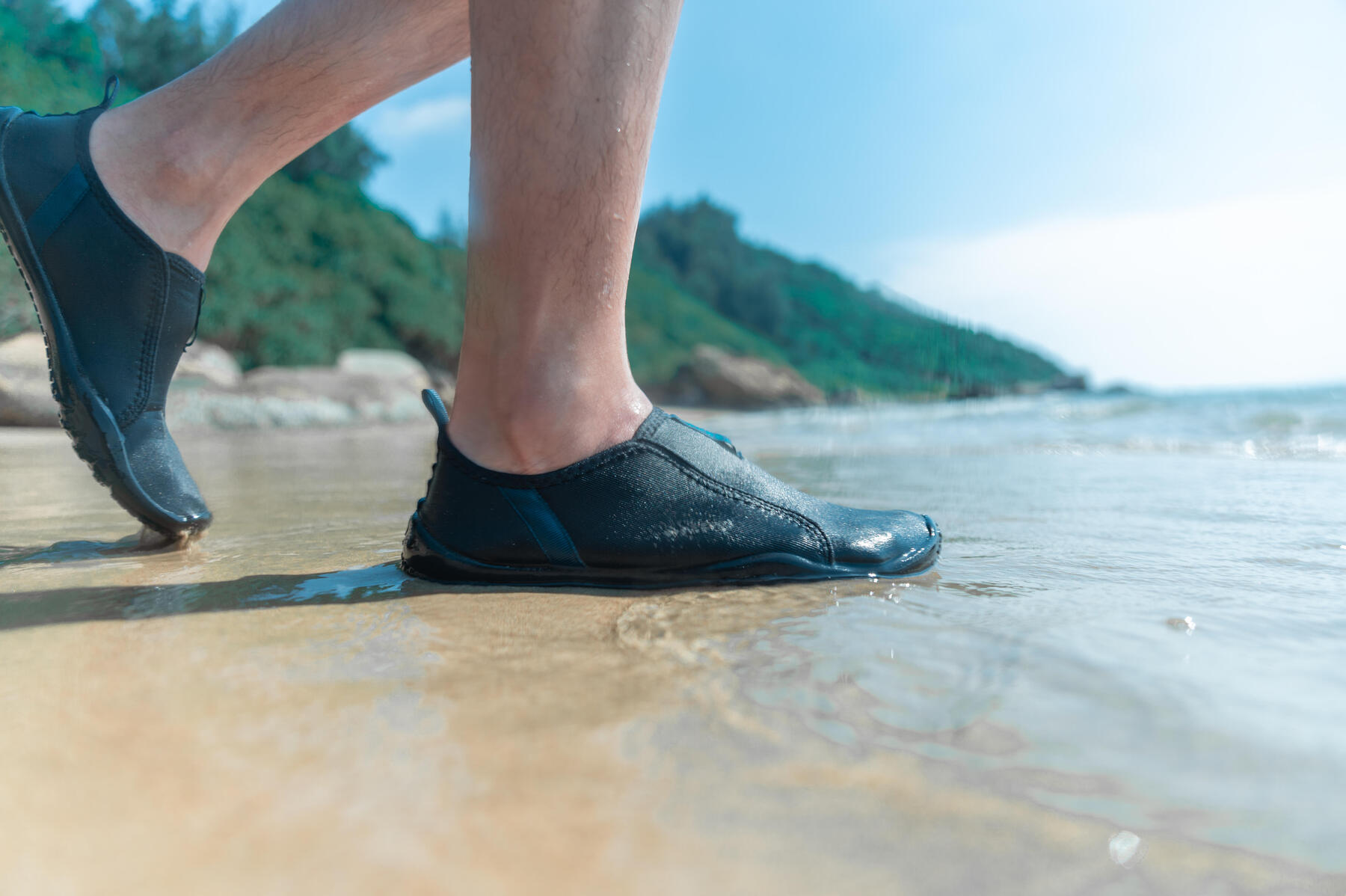 Mężczyzna wchodzący do wody w aquashoes