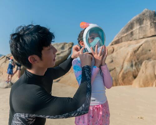 chłopiec zakładający dziewczynce maskę do snorkelinguu