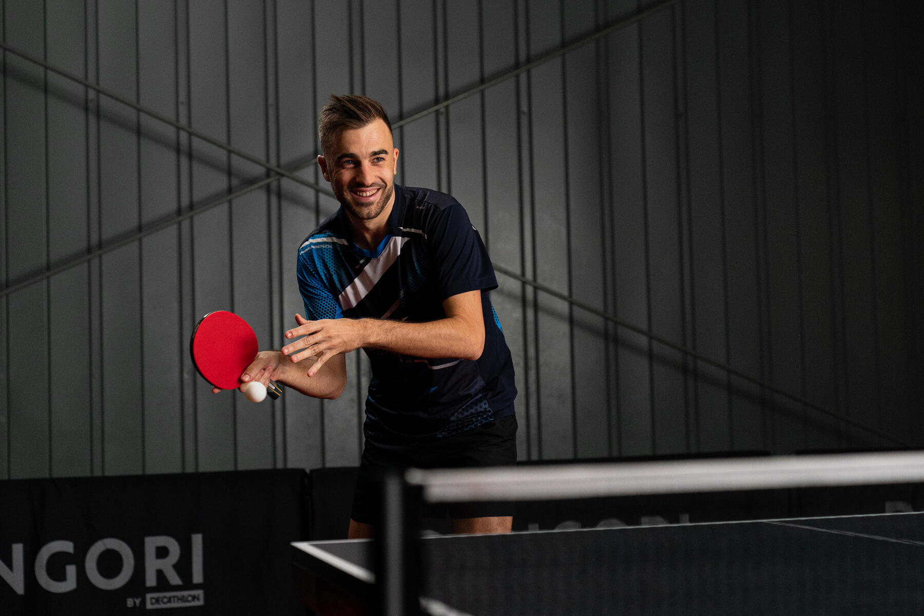 Man playing table tennis with a smile