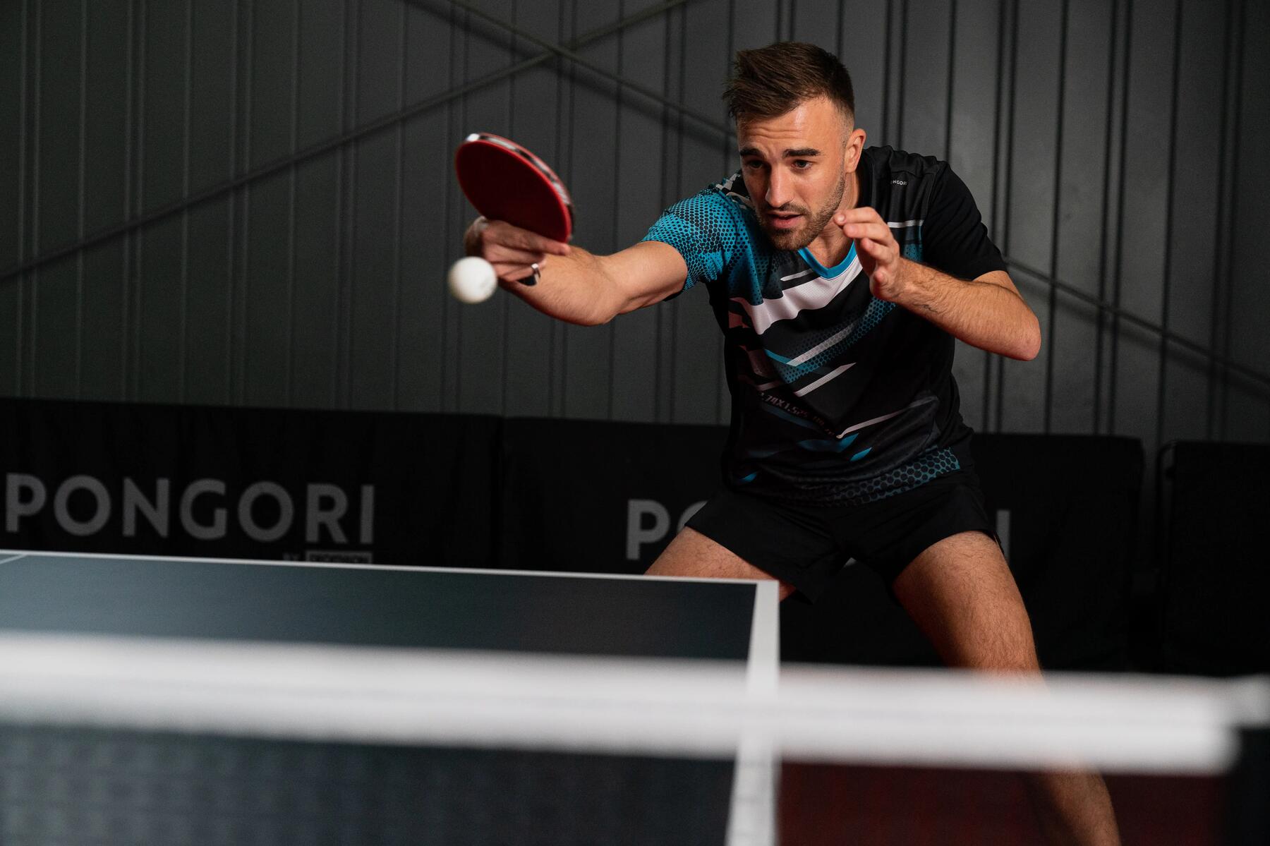 Man hitting table tennis ball with bat