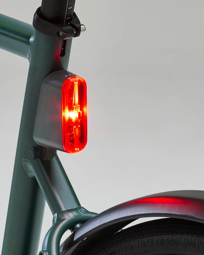 Integriertes Rücklicht und Schutzblech an grünem Fahrrad; weißer Hintergrund
