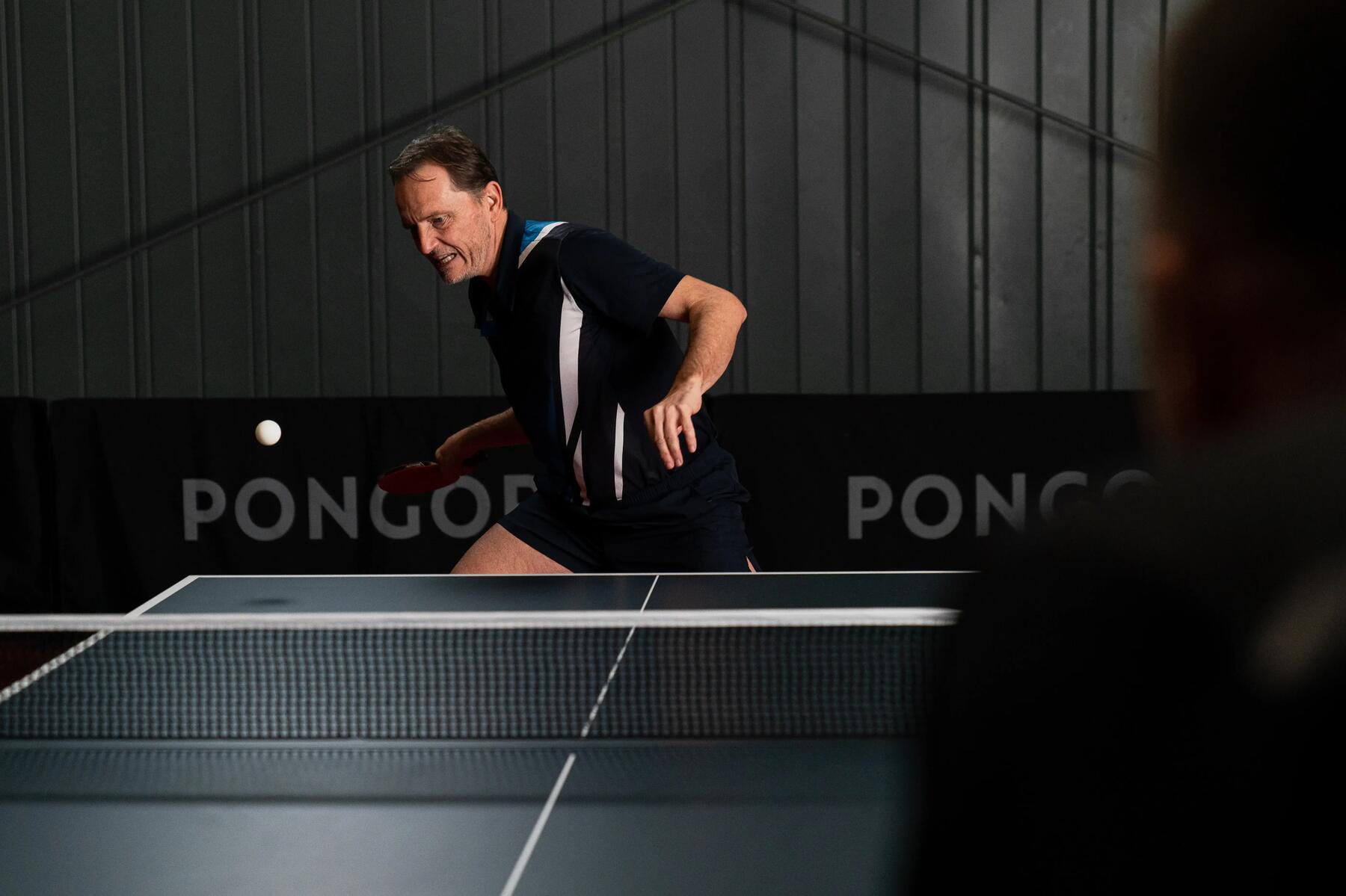 Man taking a return shot in table tennis