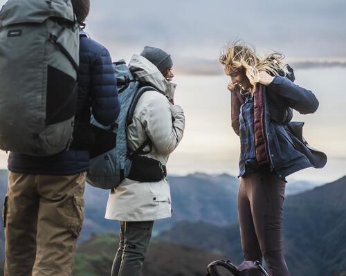 kobiety i mężczyzna w odzieży outdoorowej z plecakami w górach
