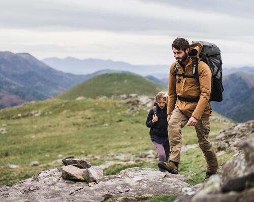 mężczyzna i kobieta z plecakami wędrujący po górach