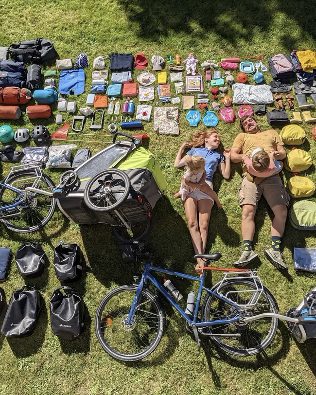 Mann fährt auf blauem Fahrrad stehend durch den Wald