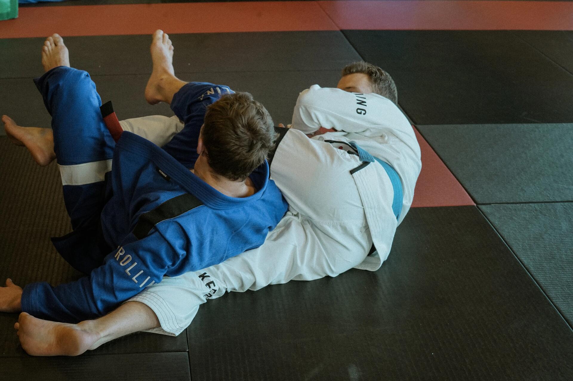 Jiu-Jitsu-Kämpfer fixiert seinen Partner am Boden in einer Festnahme-Position