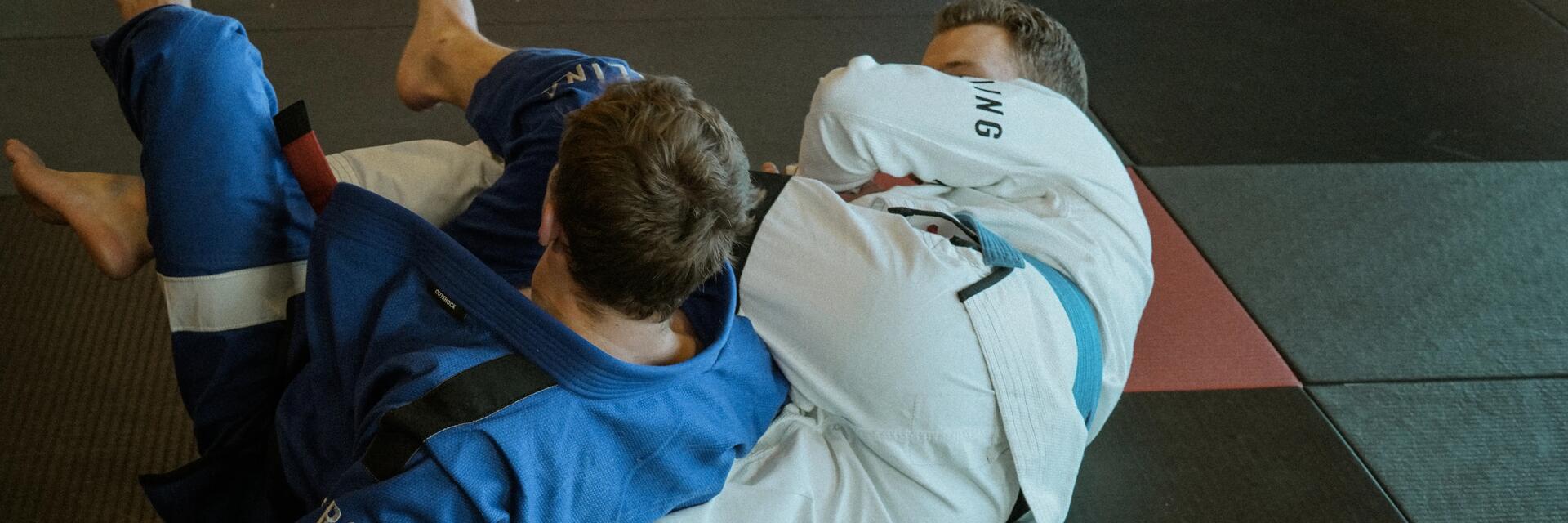 Mężczyźni trenujący techniki obalenia w sambo combat