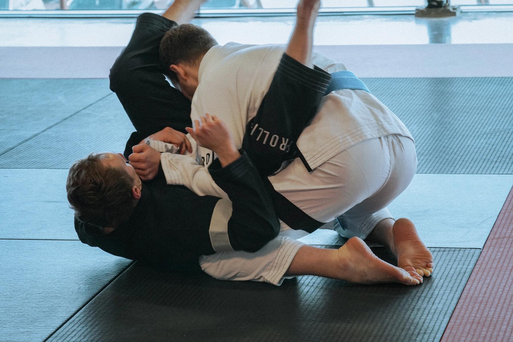 Mężczyźni trenujący techniki obalenia w sambo combat