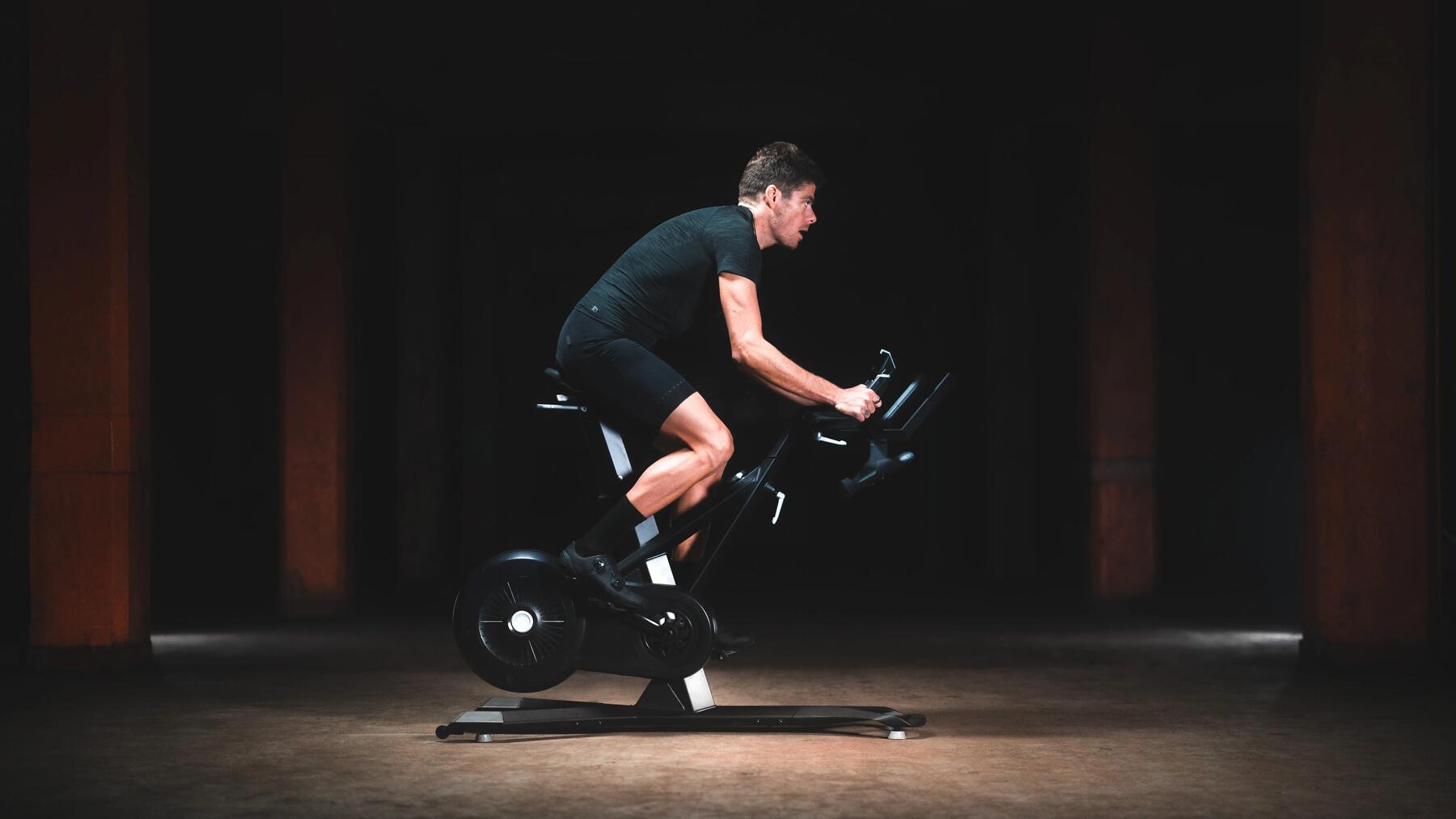Mężczyzna w odzieży sportowej trenujący na rowerze stacjonarnym