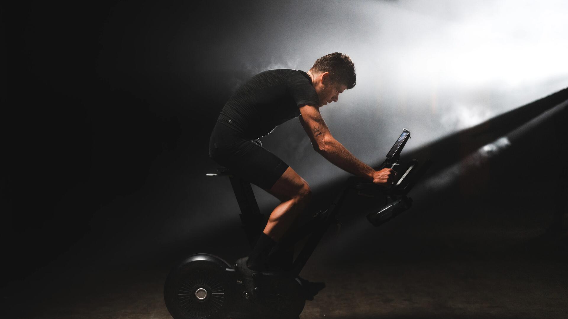 Sportowiec jadący na rowerze stacjonarnym