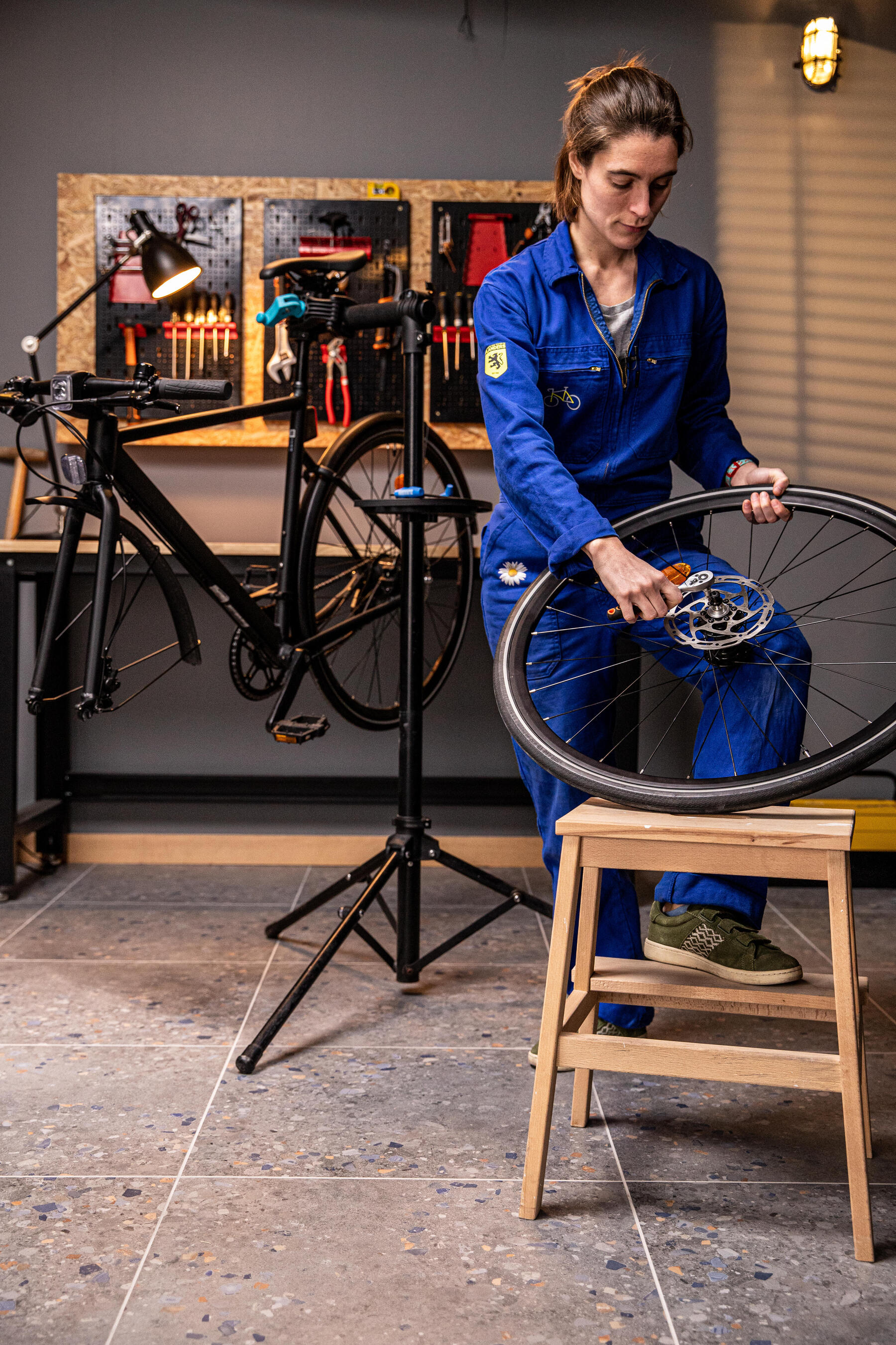 Kobieta pracująca w serwisie rowerowym demontująca dętkę z koła roweru