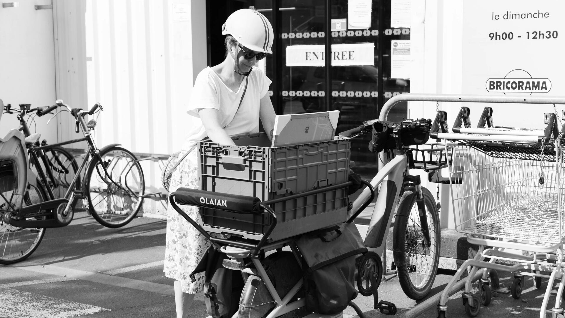 Une femme qui charge son vélo cargo Decathlon