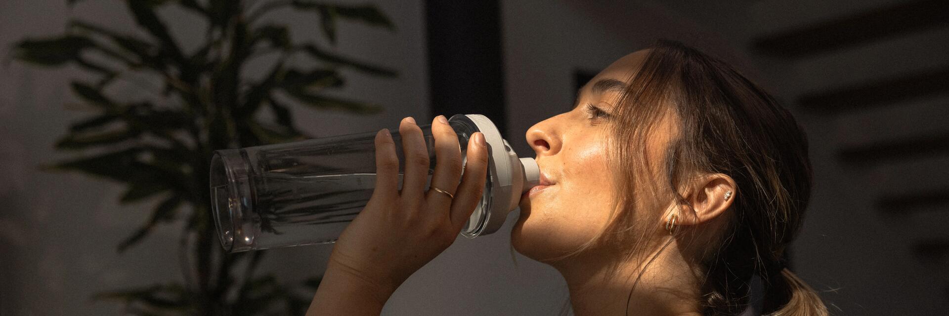 Kobieta pijąca wodę z cytruliną z bidonu