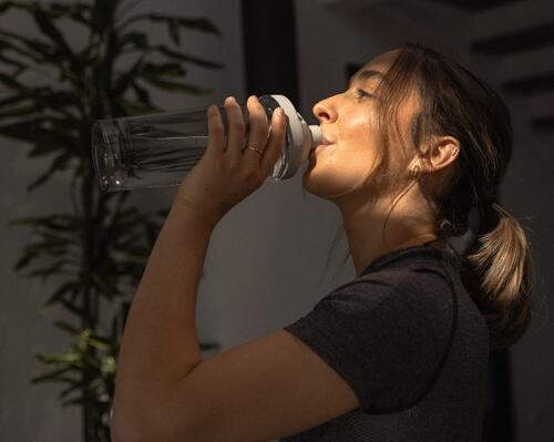 Kobieta pijąca wodę z cytruliną z bidonu