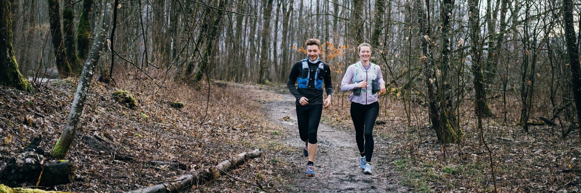 Kobieta i mężczyzna w odzieży sportowej biegający po lesie