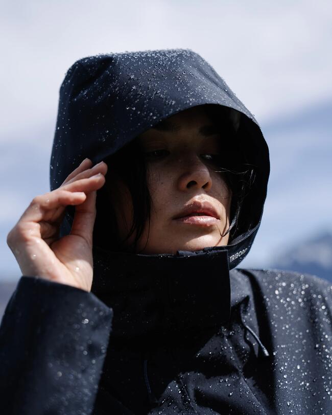Frau mit nasser, dunkelblauer Jacke und Kapuze