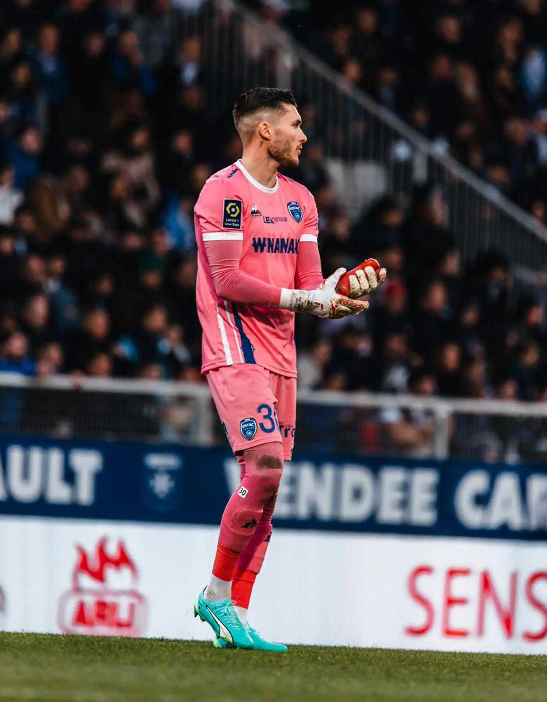 Bramkarz biegnący stojący na boisku podczas meczu w rękawicach bramkarskich