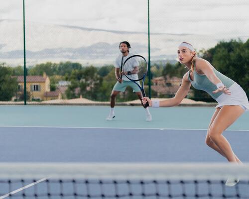 kobieta i mężczyzna w odzieży tenisowej grający w tenisa na korcie