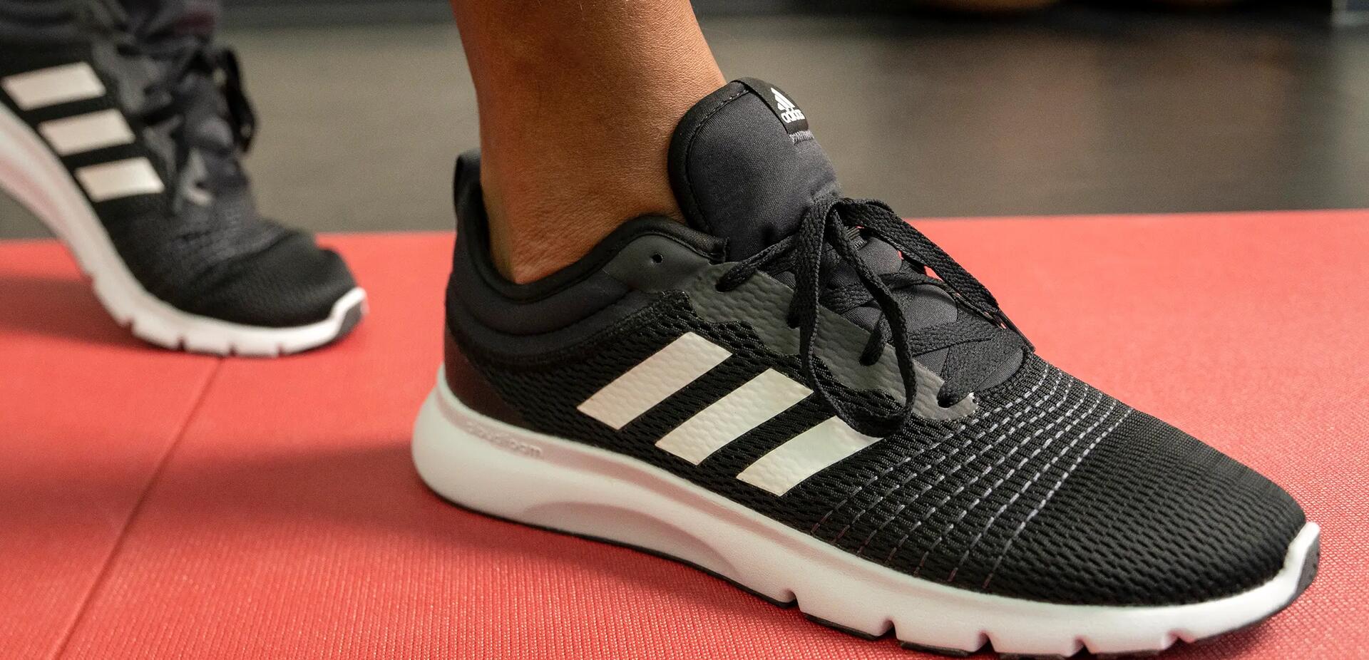 osoba w butach fitness stojąca na macie do ćwiczeń