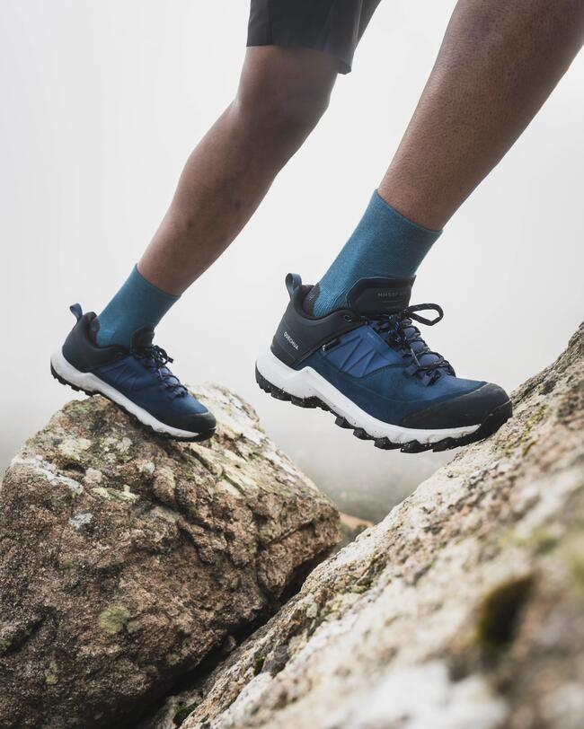 person auf einem Fels mit Wanderschuhen