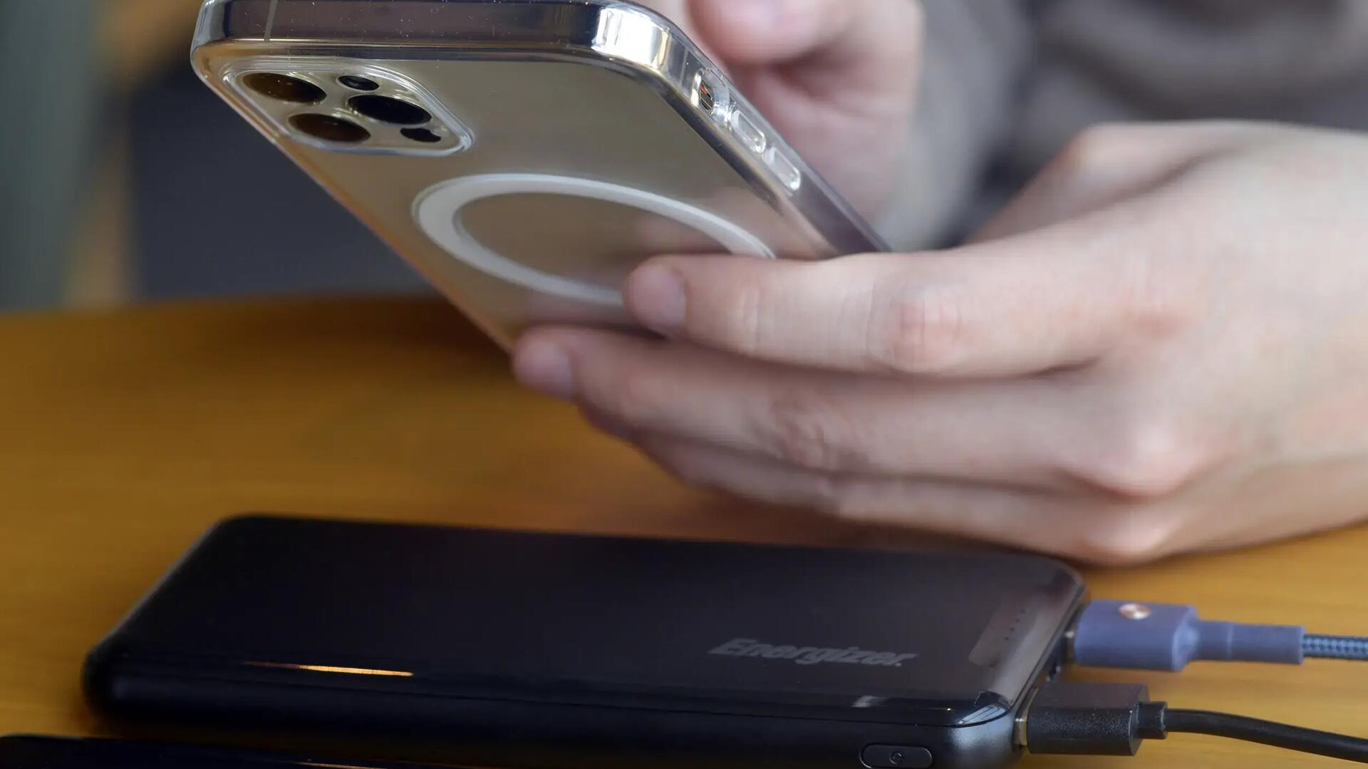 Osoba ładująca telefon power bankiem