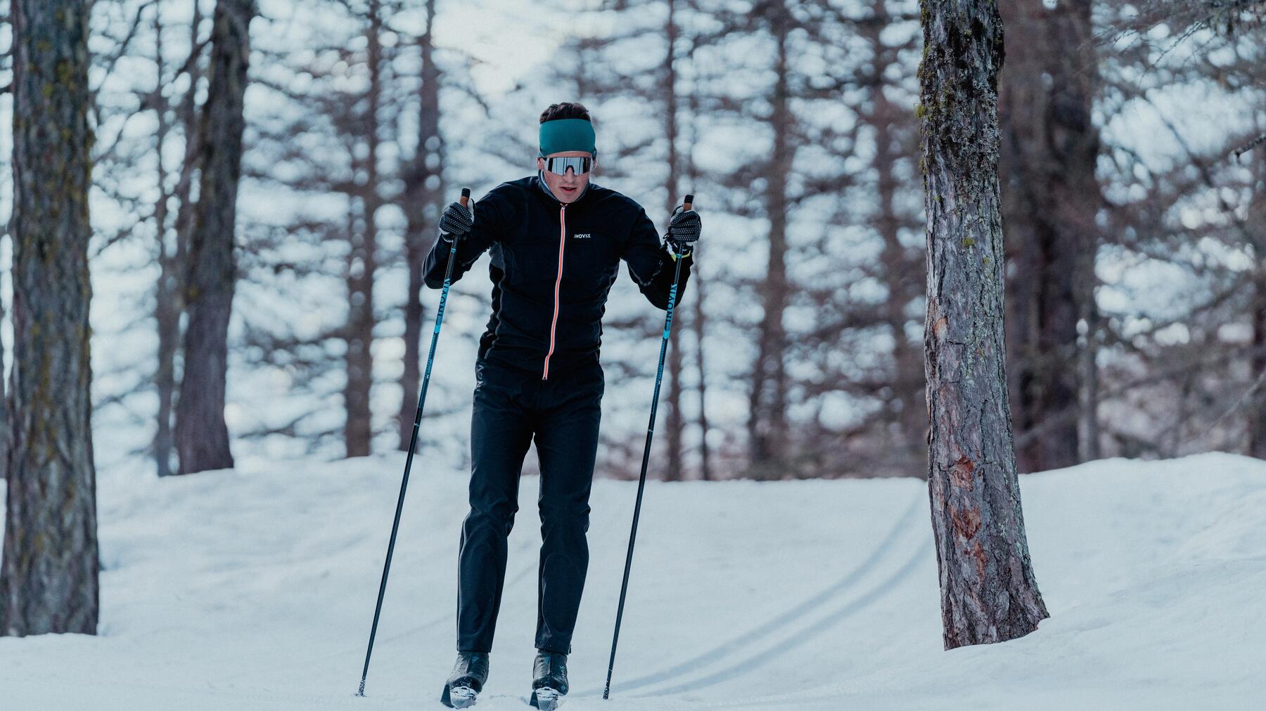 young boy holding cross-country skis and poles