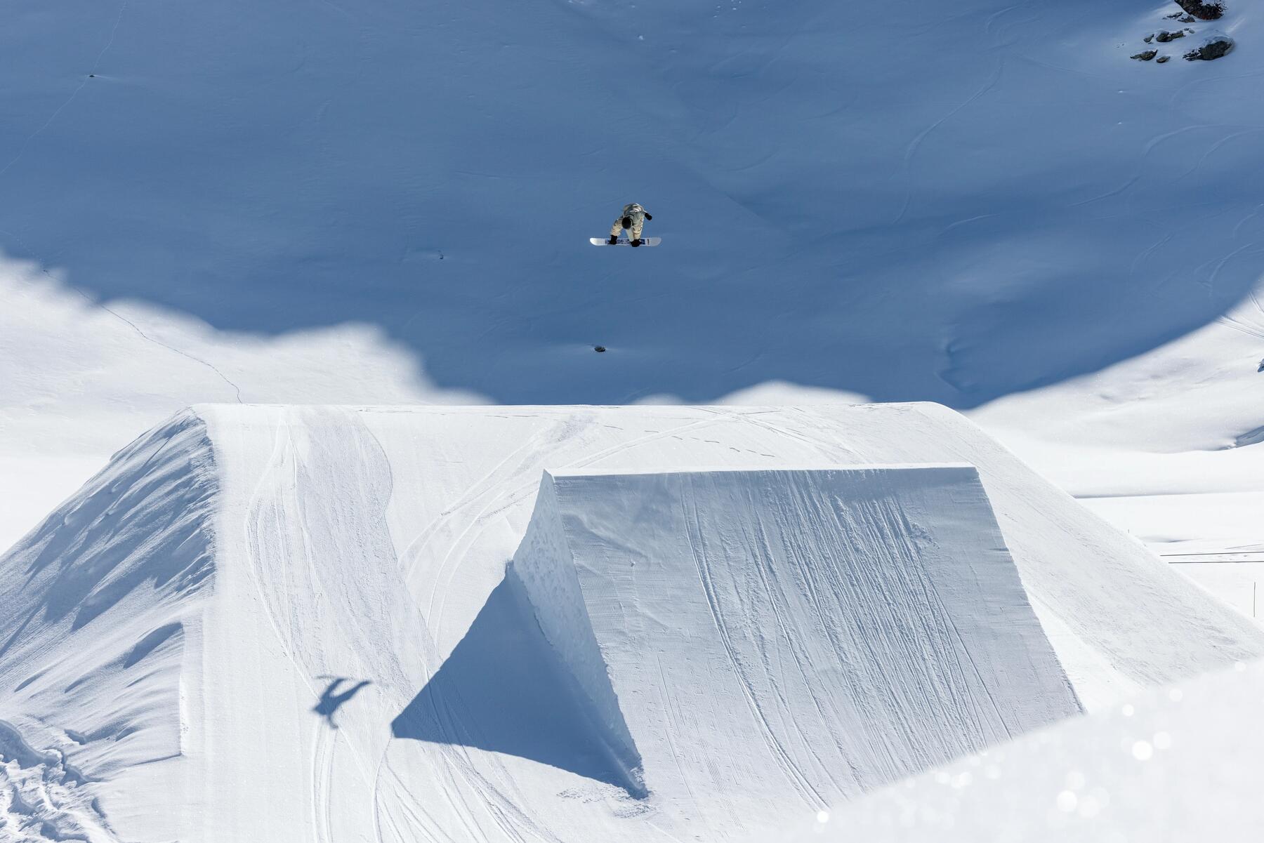 Mężczyzna lecący w powietrzu na desce snowboardowej
