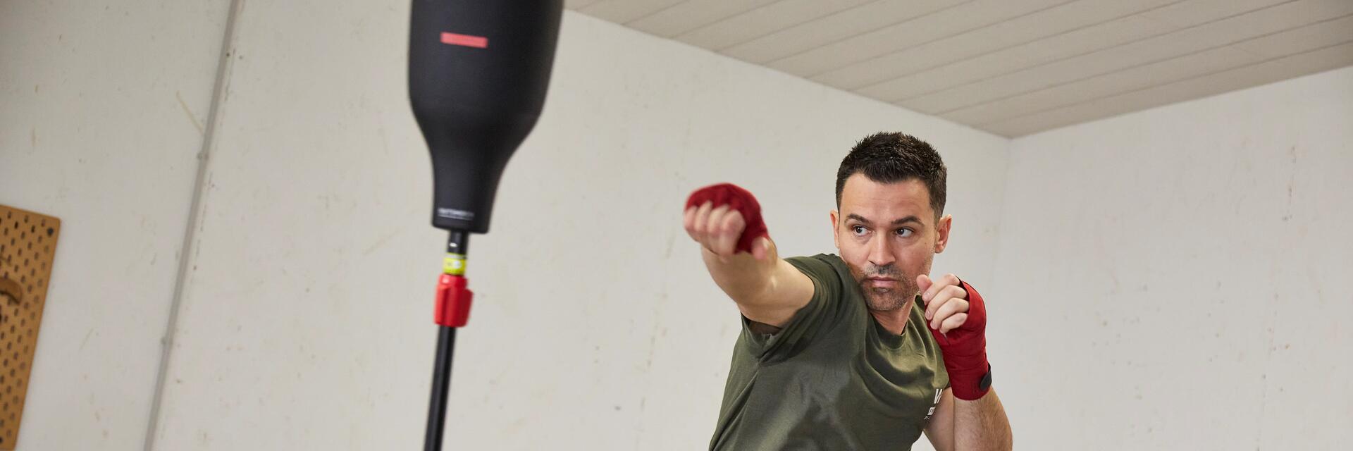 Mężczyzna trenujący kickboxing w domu ruch jab