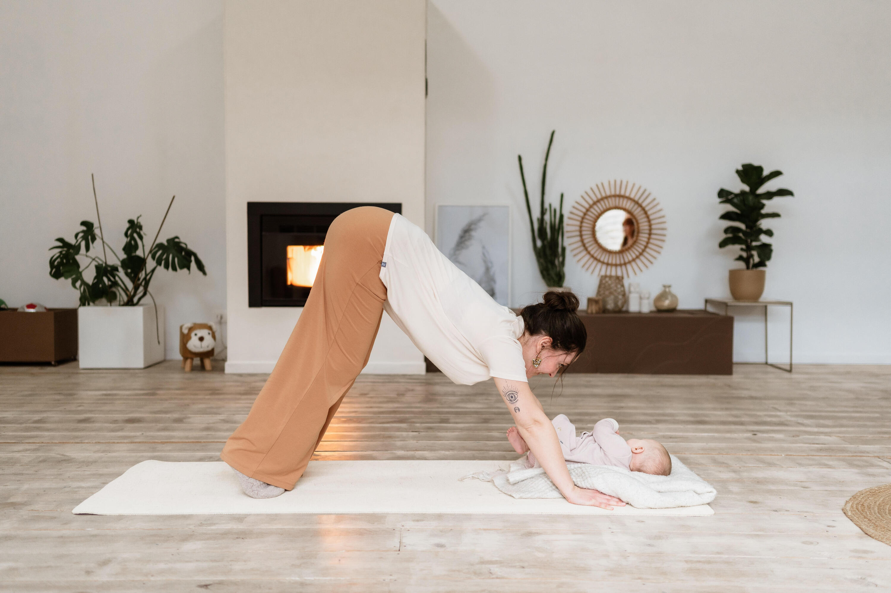 mulher a fazer yoga com um bebé em frente