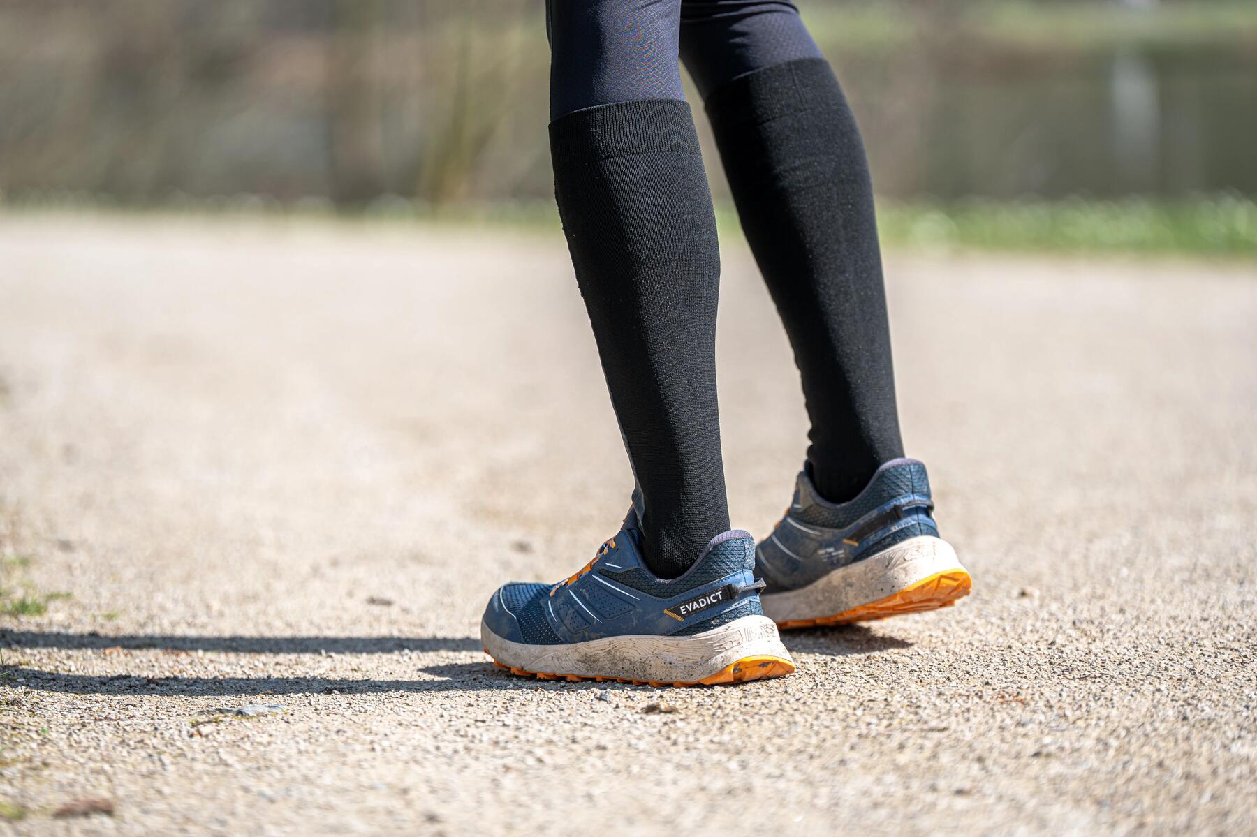 woman watching the terrain while running on a trail in the fall