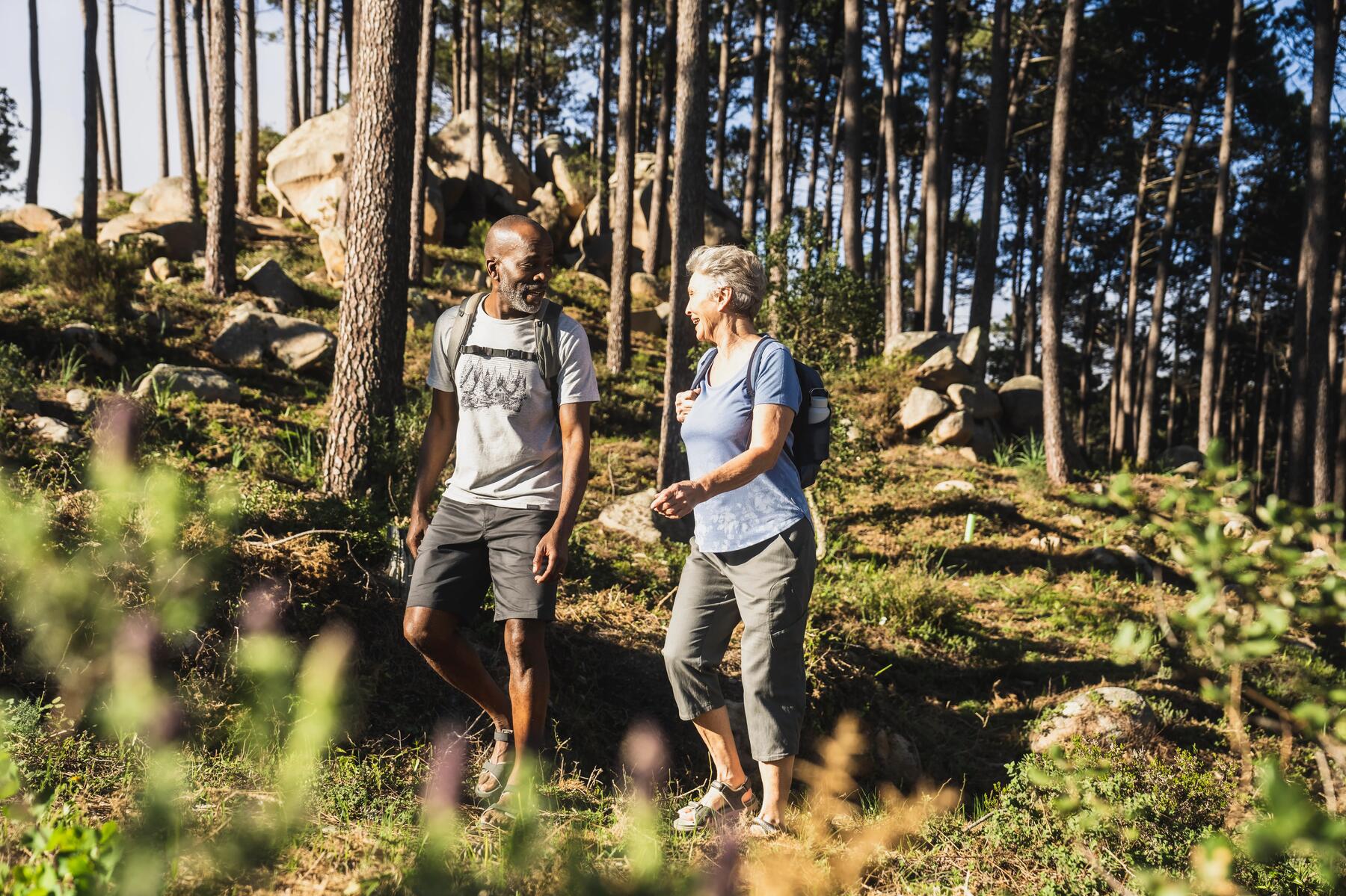 Een oudere man en vrouw wandelen samen door de natuur
