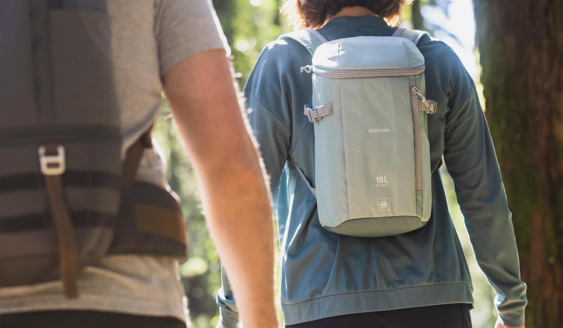 Man and woman wearing hiking backpacks.