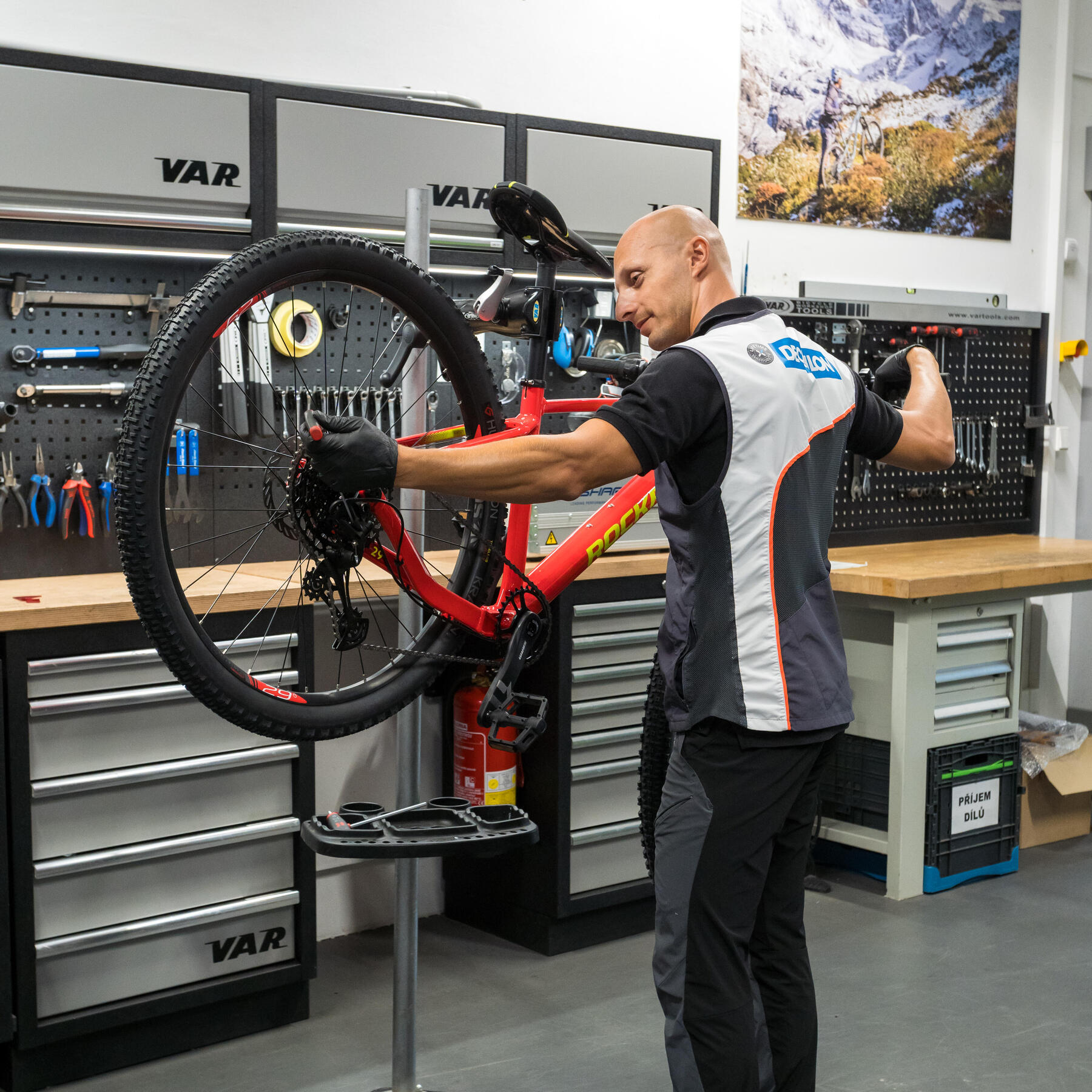 Een Decathlon fietsexpert stelt de kabelspanning in van een fiets
