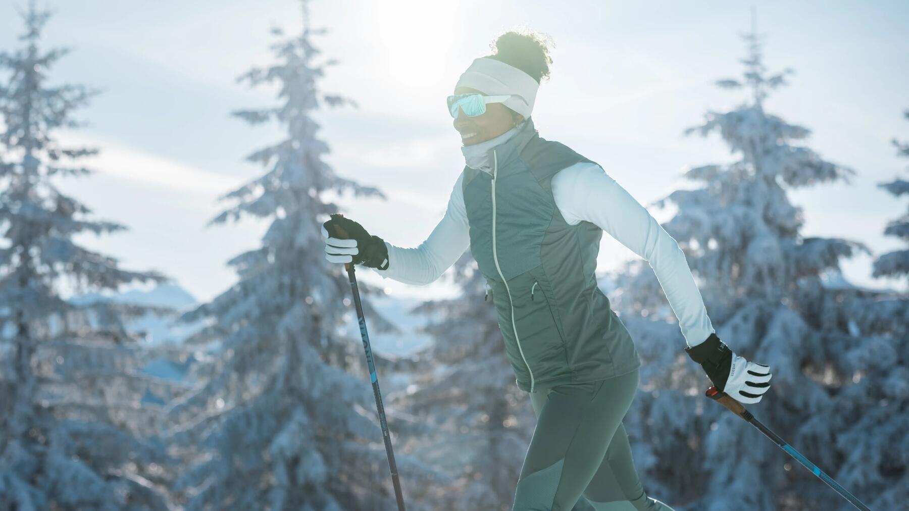 two people cross-country skiing through a forest