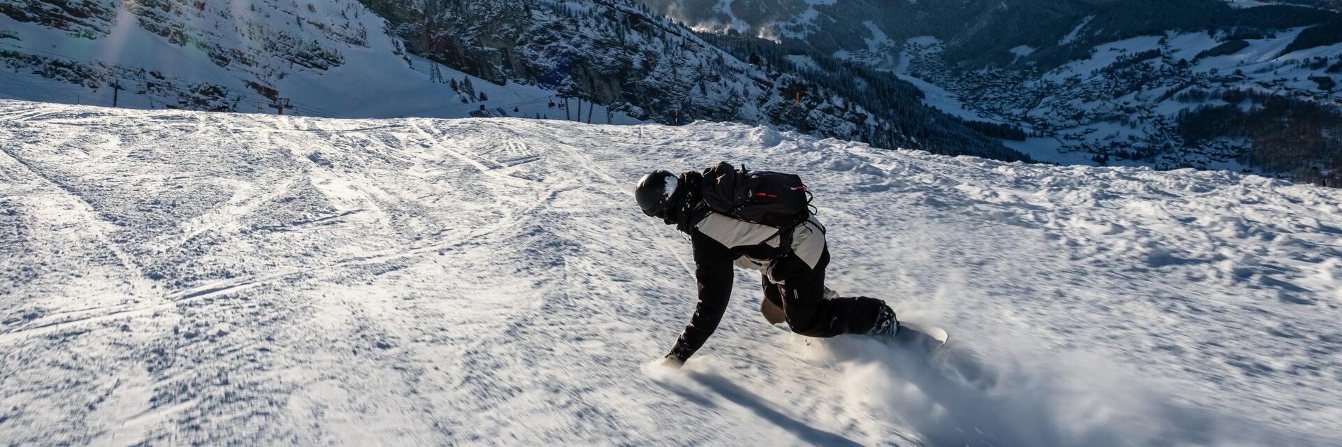 Man die lekker aan het snowboarden is op de piste