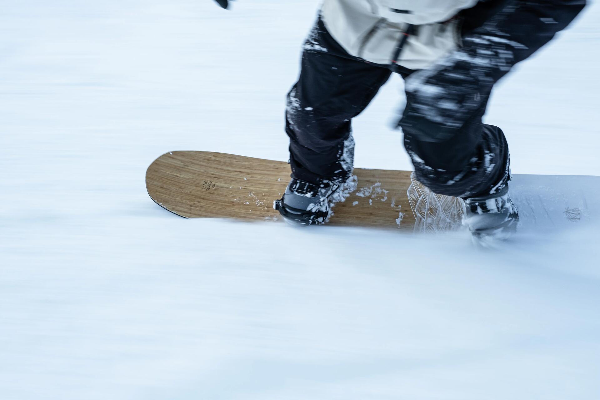 Mężczyzna stojący na desce snowboardowej