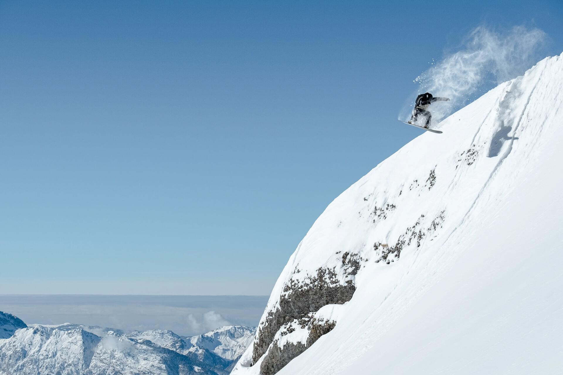 Snowboardzista zjeżdżający na stoku na desce