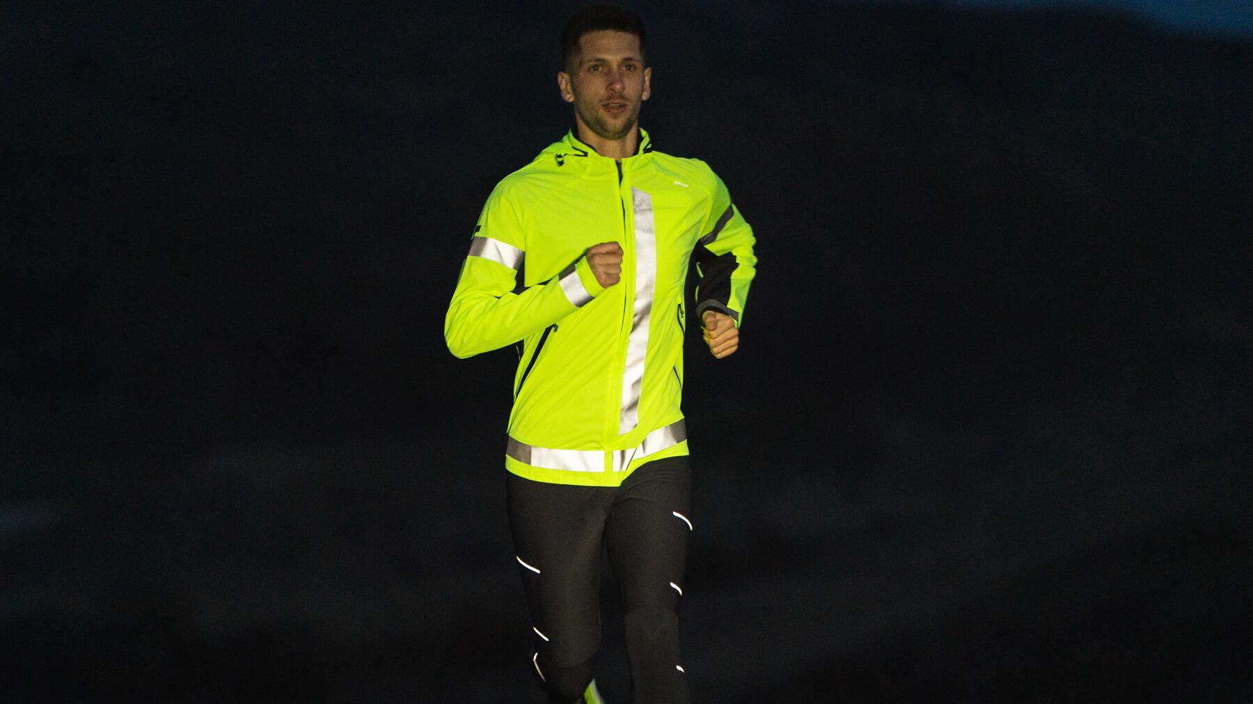 Mężczyzna w odzieży sportowej odblaskowej trenujący bieganie nocą