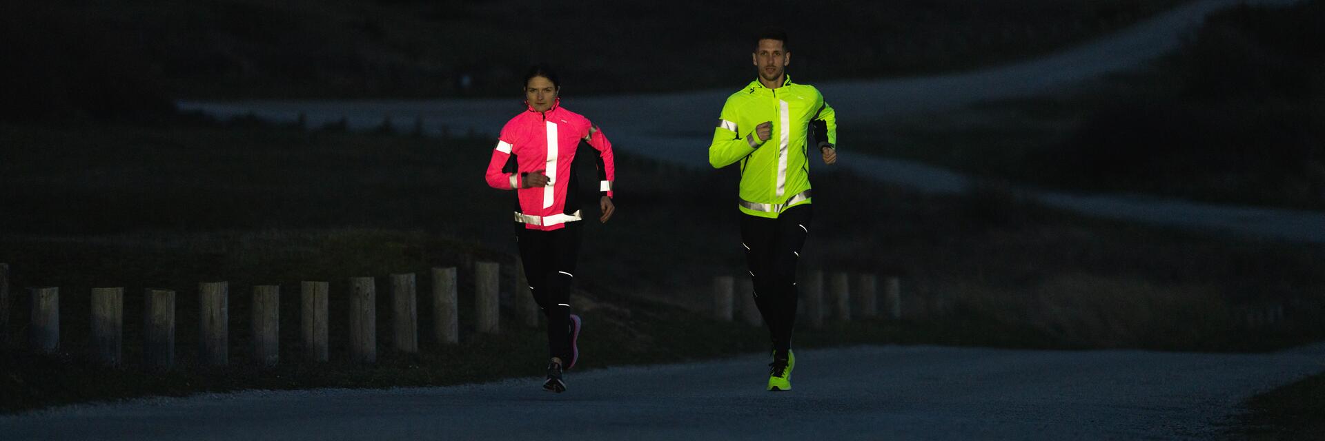 Para biorąca udział w biegu nocnym w odzieży sportowej z odblaskami